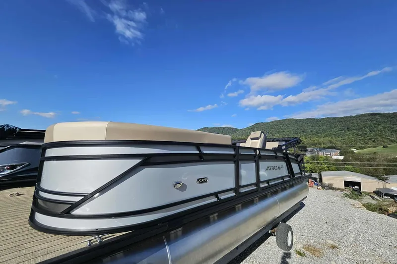 Slide: The Image of 2026 Starcraft EXS 3 Q DH pontoon boat on gravel, scenic mountain backdrop. - 11