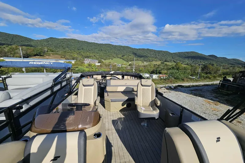 Slide: The Image of 2026 Starcraft EXS 3 Q DH pontoon boat with beige seating, set against a scenic mountain backdrop. - 7