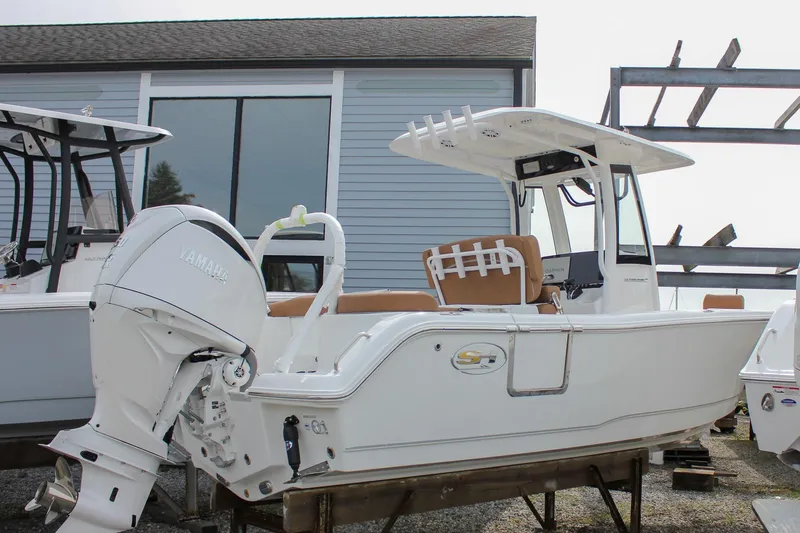 Slide: The Image of 2026 Sea Hunt Ultra 235 SE boat with Yamaha engine, docked near a building. - 10