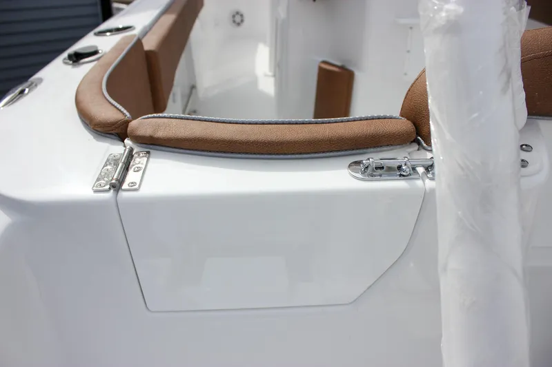 Slide: The Image of 2026 Sea Hunt Ultra 235 SE boat interior with brown cushioned seating and white finish. - 12