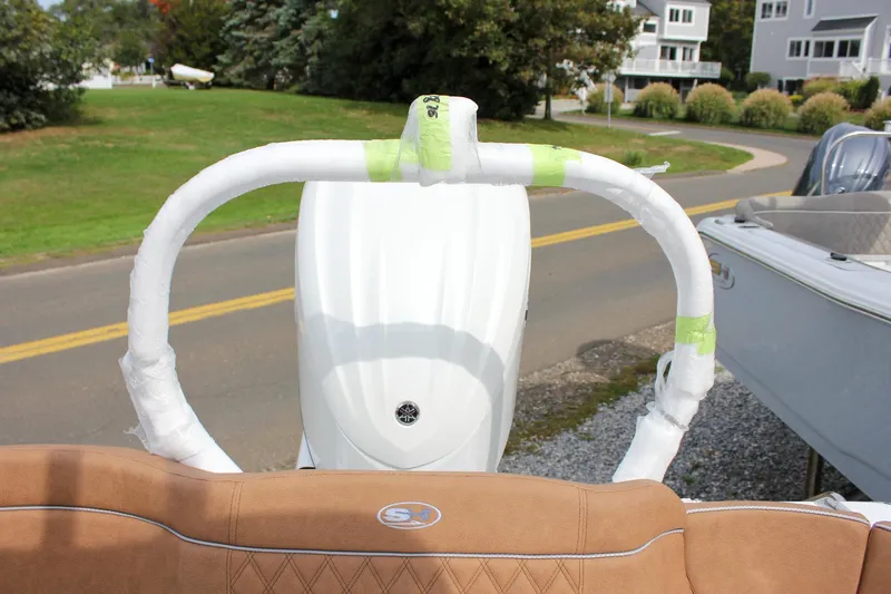 Slide: The Image of 2026 Sea Hunt Ultra 235 SE boat with wrapped components, parked near a road. - 17