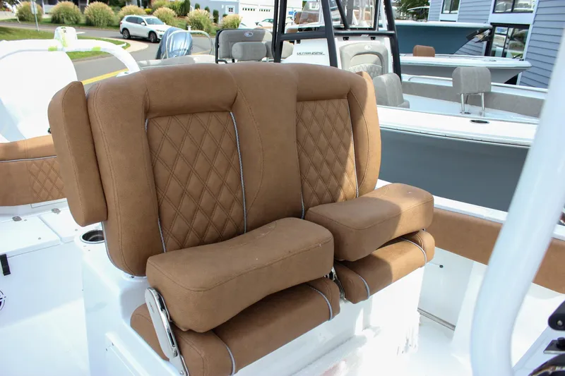 Slide: The Image of Luxurious seating on 2026 Sea Hunt Ultra 235 SE boat, featuring brown diamond-stitched upholstery. - 22