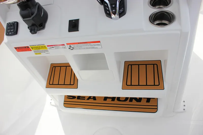 Slide: The Image of 2026 Sea Hunt Ultra 235 SE boat console with controls and cup holders. - 24