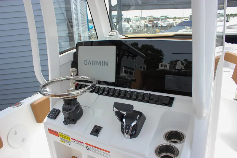 Slide: The Image of 2026 Sea Hunt Ultra 235 SE boat dashboard with Garmin navigation system and steering wheel. - 25