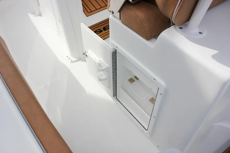 Slide: The Image of 2026 Sea Hunt Ultra 235 SE boat interior with storage compartment and cushioned seating. - 26