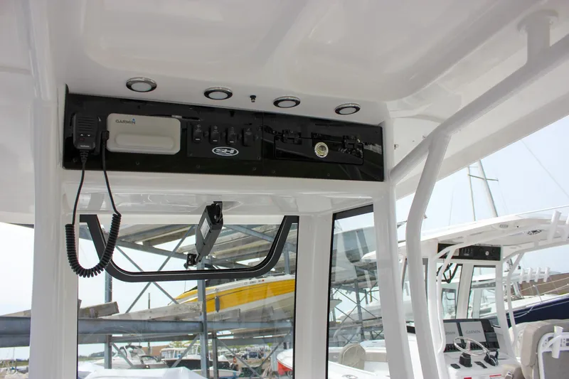 Slide: The Image of 2026 Sea Hunt Ultra 235 SE boat console with Garmin electronics and overhead storage. - 27