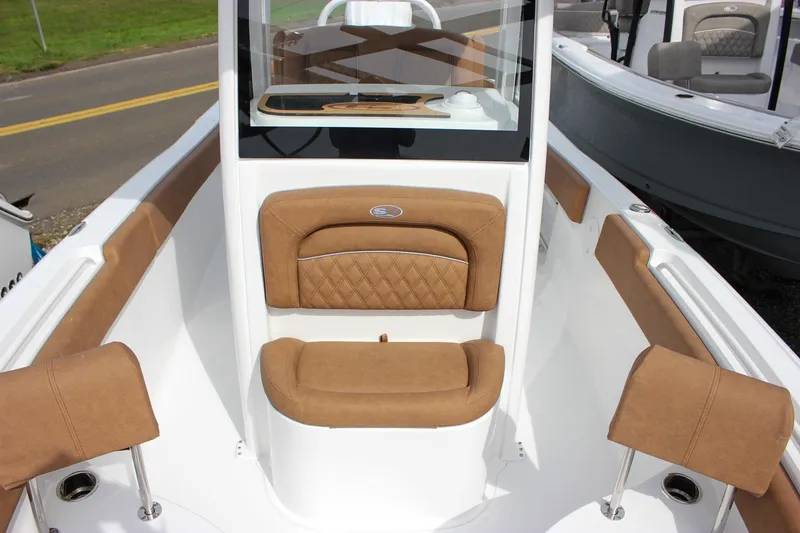Slide: The Image of 2026 Sea Hunt Ultra 235 SE boat interior with tan cushioned seating and sleek design. - 32