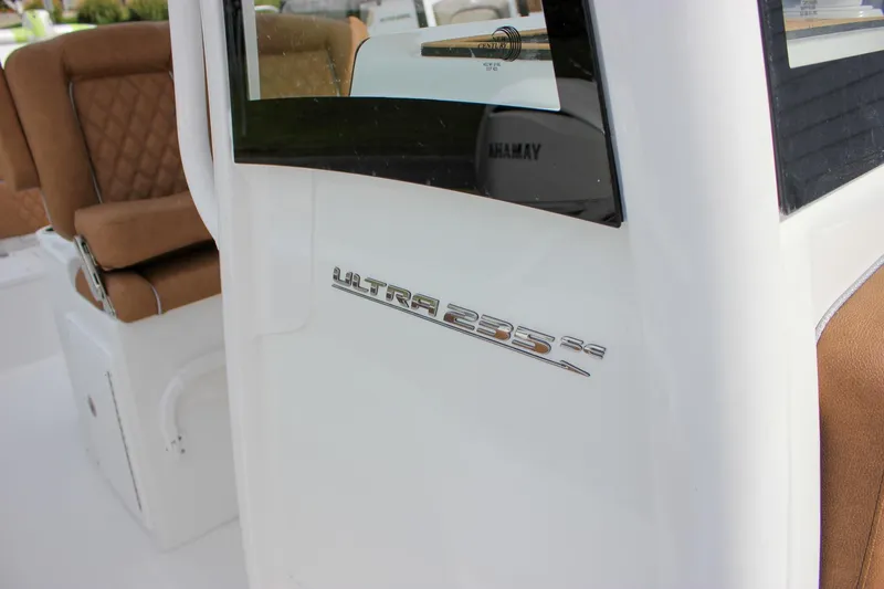 Slide: The Image of 2026 Sea Hunt Ultra 235 SE boat interior with brown seating and model emblem. - 36
