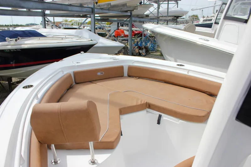 Slide: The Image of 2026 Sea Hunt Ultra 235 SE boat with tan seating in a marina. - 45