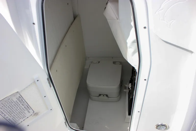 Slide: The Image of Interior view of 2026 Sea Hunt Ultra 235 SE boat's compact restroom area. - 46