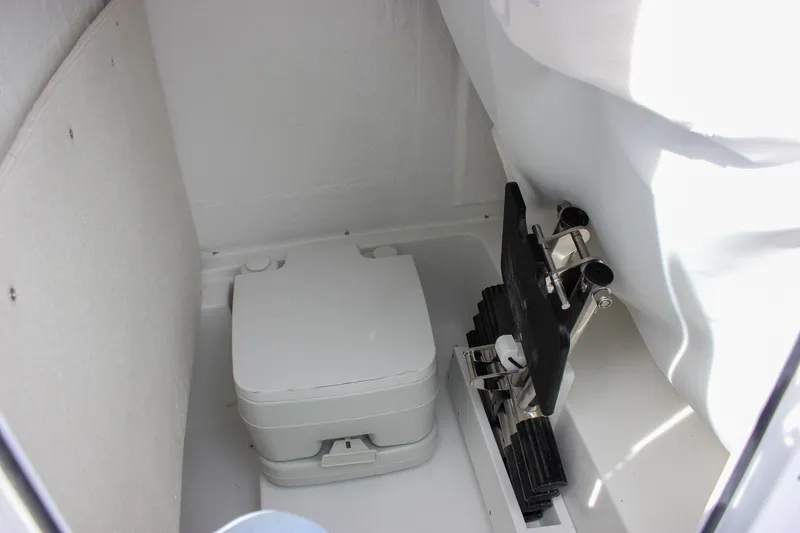 Slide: The Image of 2026 Sea Hunt Ultra 235 SE boat interior with compact marine toilet. - 48