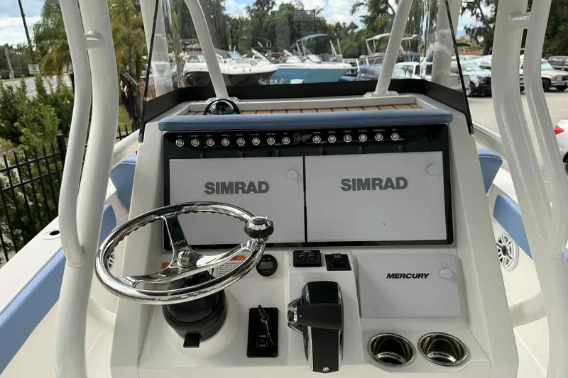 Slide: The Image of 2026 Ranger 2660 Bay boat dashboard with Simrad displays and Mercury controls. - 2