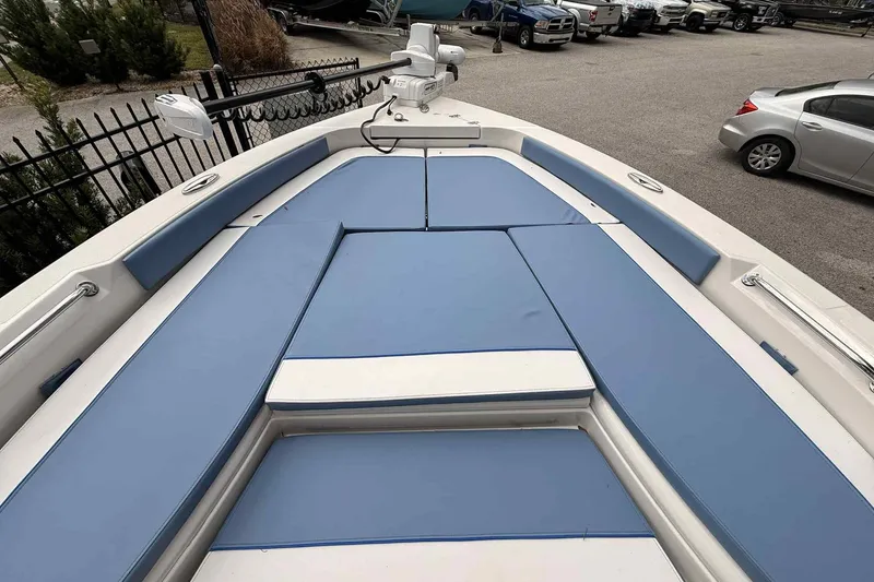 Slide: The Image of 2026 Ranger 2660 Bay boat with blue cushioned seating in a parking area. - 5