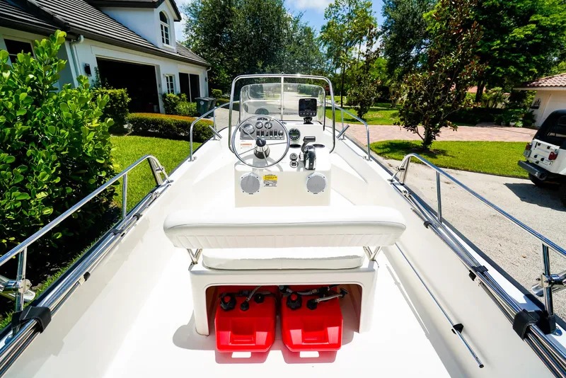 Slide: The Image of 2016 Boston Whaler 170 Montauk boat interior with steering console and red fuel tanks. - 6