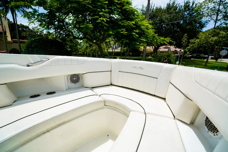 Slide: The Image of 2010 Sea Ray 270 SLX boat interior with white seating and lush greenery background. - 23