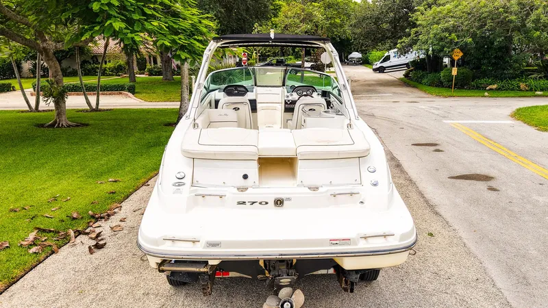 Slide: The Image of 2010 Sea Ray 270 SLX boat parked on a residential street, surrounded by greenery. - 29
