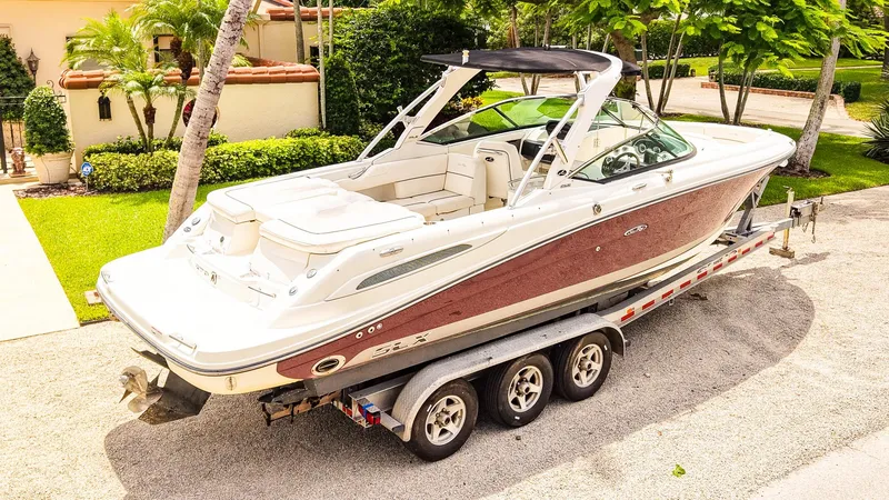 Slide: The Image of 2010 Sea Ray 270 SLX boat on trailer, parked in a lush residential driveway. - 3