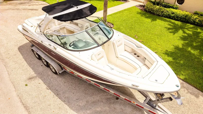 Slide: The Image of 2010 Sea Ray 270 SLX boat on trailer, parked on driveway near green lawn. - 4