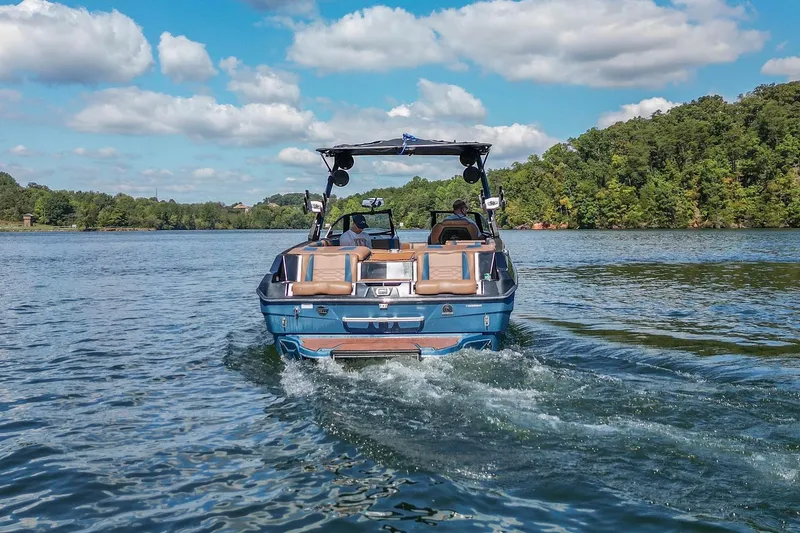 Slide: The Image of 2022 Malibu Wakesetter 25 LSV cruising on a scenic lake under a blue sky. - 10