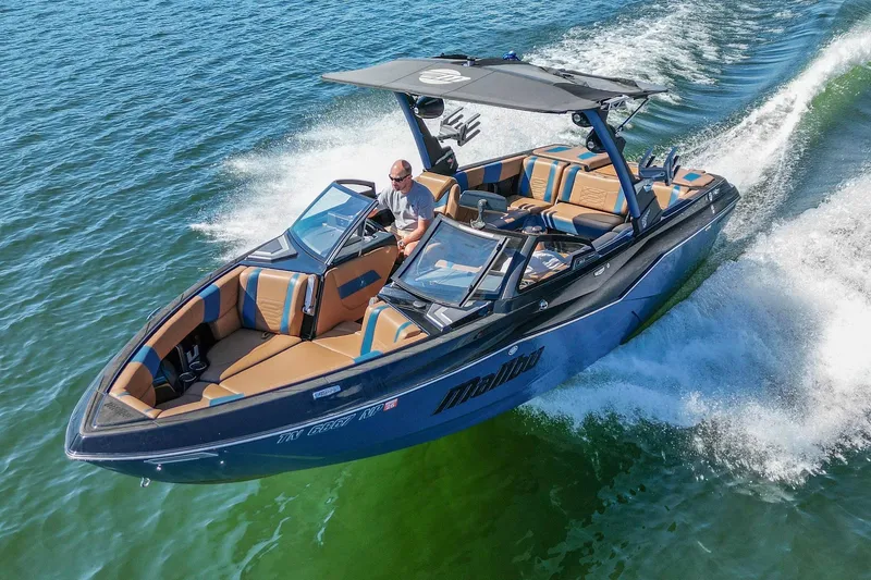 Slide: The Image of 2022 Malibu Wakesetter 25 LSV cruising on open water, showcasing sleek design and luxury. - 11