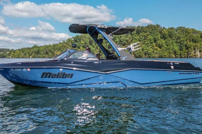 Slide: The Image of 2022 Malibu Wakesetter 25 LSV boat cruising on a scenic lake. - 3