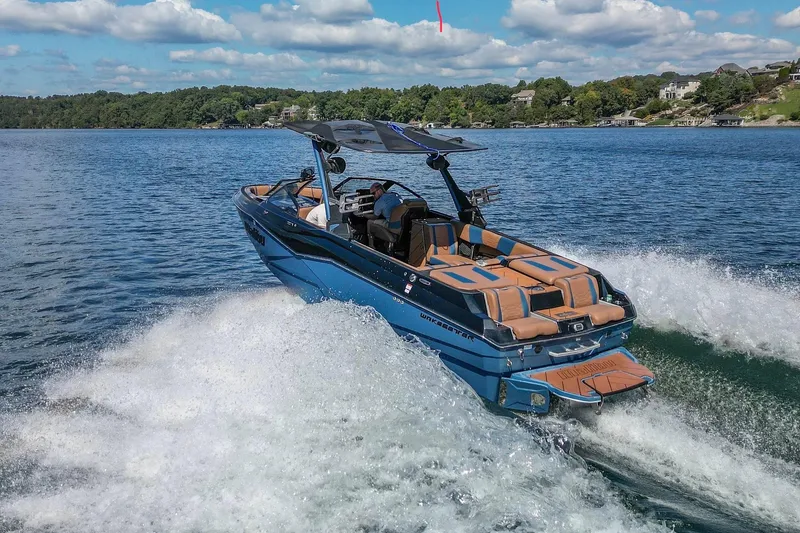 Slide: The Image of 2022 Malibu Wakesetter 25 LSV cruising on a scenic lake under a blue sky. - 4