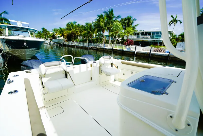 Slide: The Image of 2018 World Cat 320 CC boat docked near palm trees and waterfront homes. - 11