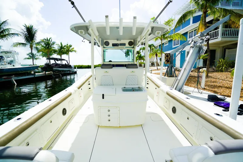 Slide: The Image of 2018 World Cat 320 CC boat docked, featuring spacious deck and modern amenities, surrounded by palm trees. - 12