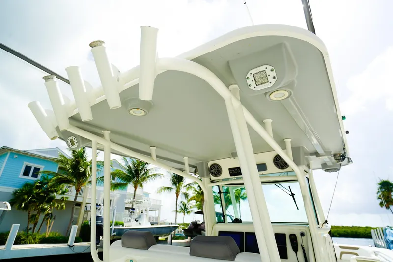 Slide: The Image of 2018 World Cat 320 CC boat with rod holders and electronics, docked near palm trees. - 13
