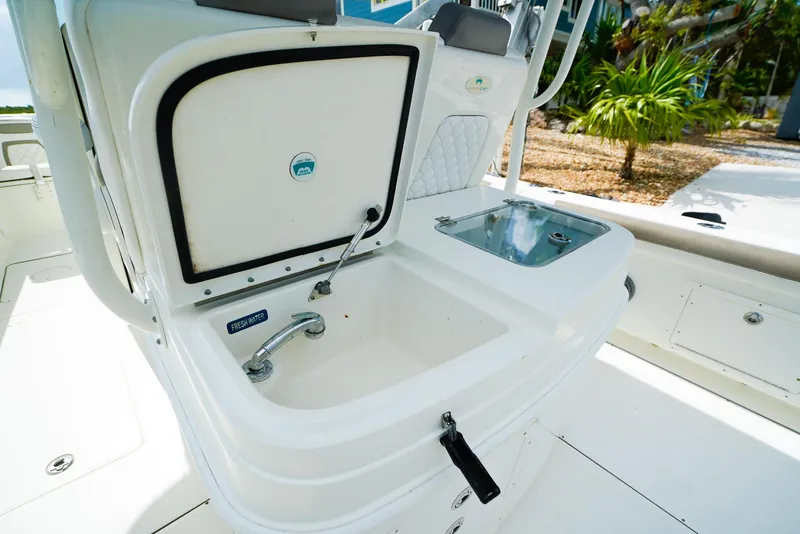 Slide: The Image of 2018 World Cat 320 CC boat sink and storage area with fresh water tap. - 14