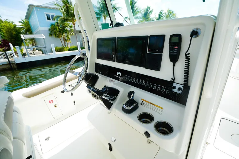 Slide: The Image of 2018 World Cat 320 CC boat dashboard with steering wheel and control panel. - 23