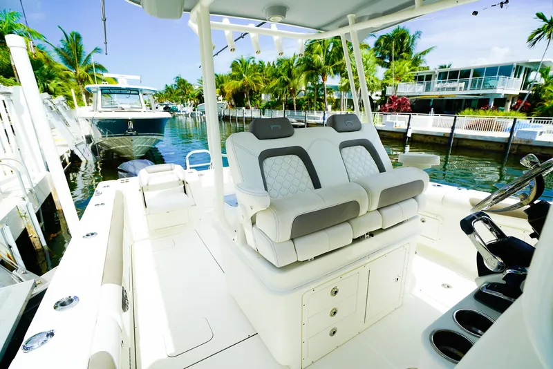 Slide: The Image of 2018 World Cat 320 CC boat interior with luxurious seating, docked near waterfront homes. - 25