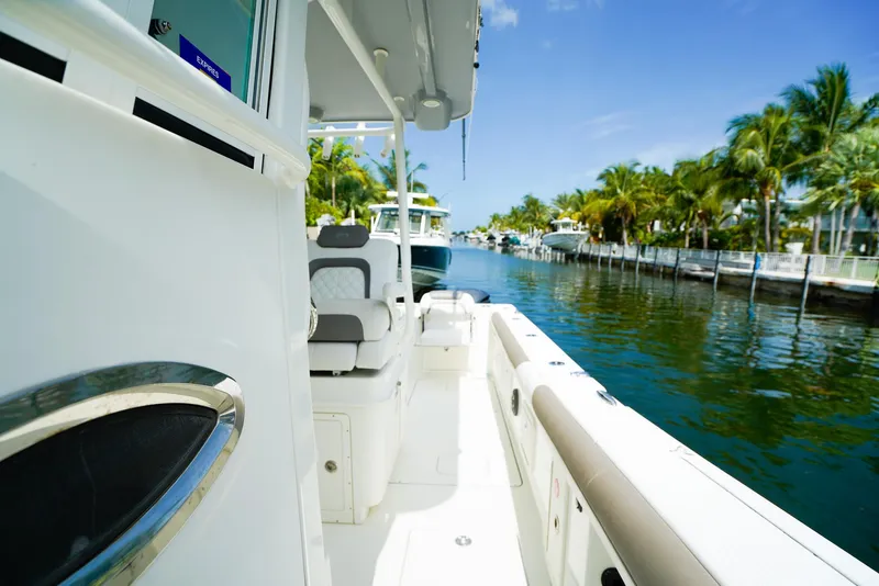 Slide: The Image of 2018 World Cat 320 CC boat docked in a tropical marina with palm trees. - 26