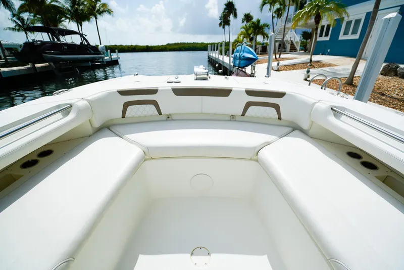Slide: The Image of 2018 World Cat 320 CC boat interior with white seating, docked near palm trees. - 33