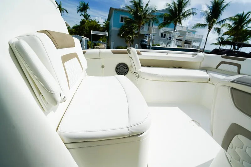 Slide: The Image of Luxurious seating on a 2018 World Cat 320 CC boat, with palm trees in the background. - 36