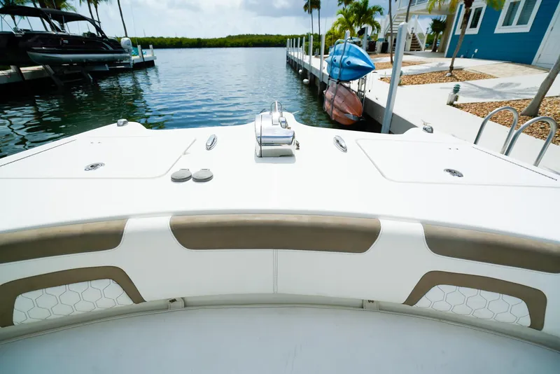 Slide: The Image of 2018 World Cat 320 CC boat docked by waterfront with kayaks and palm trees. - 38
