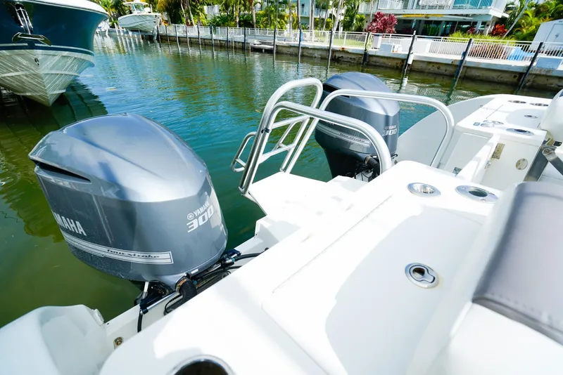 Slide: The Image of 2018 World Cat 320 CC with twin Yamaha 300 engines docked by waterfront homes. - 8