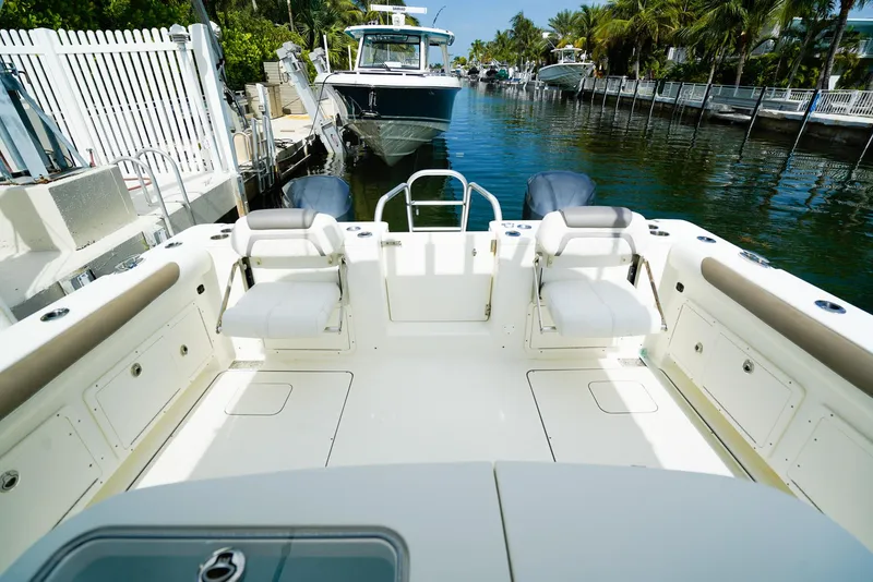 Slide: The Image of 2018 World Cat 320 CC boat interior, featuring spacious seating and sleek design in a marina setting. - 9