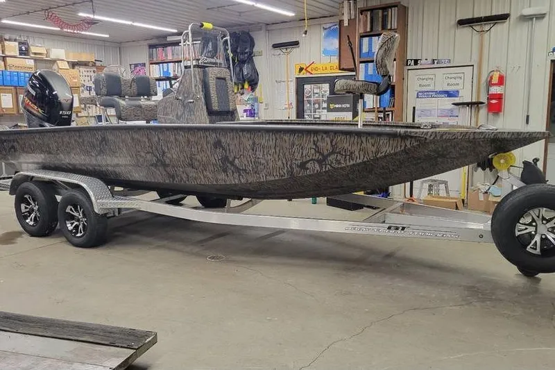 The Image of 2026 Xpress H20B Bay boat on trailer in a garage setting. - 1