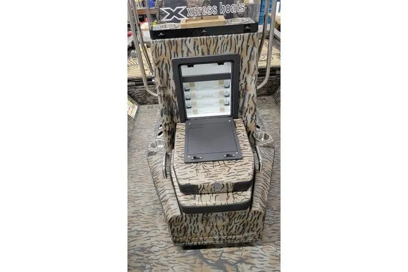 Slide: The Image of 2026 Xpress H20B Bay boat console with camouflage design and storage compartment open. - 15