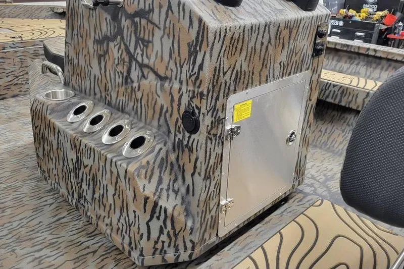 Slide: The Image of 2026 Xpress H20B Bay boat interior with camo design and storage compartment. - 22