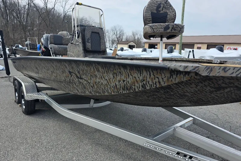 Slide: The Image of 2026 Xpress H20B Bay boat on trailer, featuring camouflage design and elevated seating. - 24