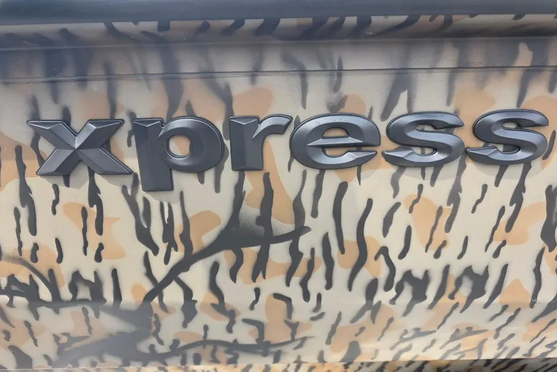 Slide: The Image of Xpress H20B Bay 2026 boat logo on camouflage-patterned surface. - 28