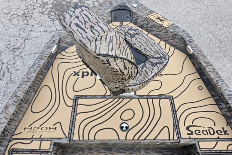 Slide: The Image of 2026 Xpress H20B Bay boat with camouflage seating and SeaDek flooring. - 34