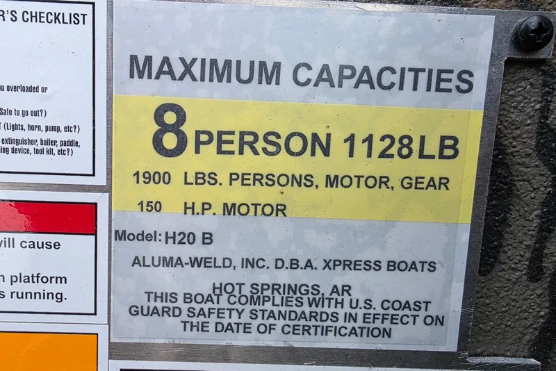 Slide: The Image of Maximum capacity label for 2026 Xpress H20B Bay boat, 8 persons, 1128 lbs. - 47