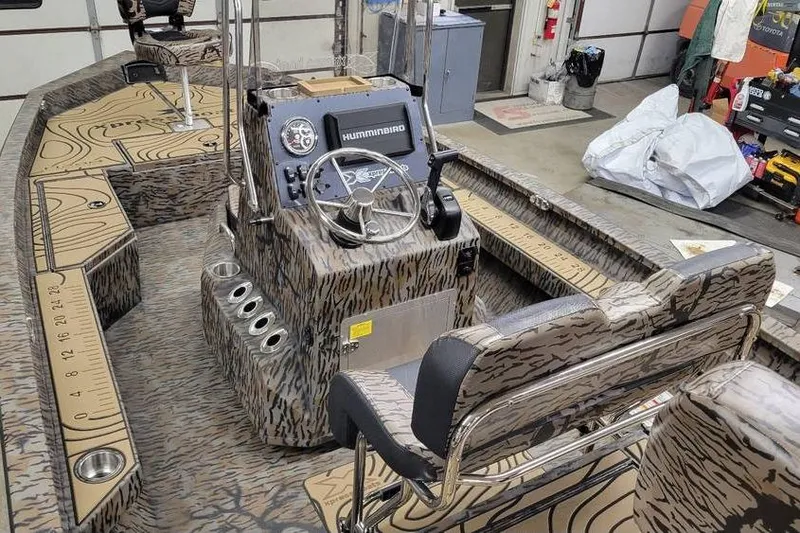 Slide: The Image of 2026 Xpress H20B Bay boat interior with camouflage design and advanced control panel. - 7