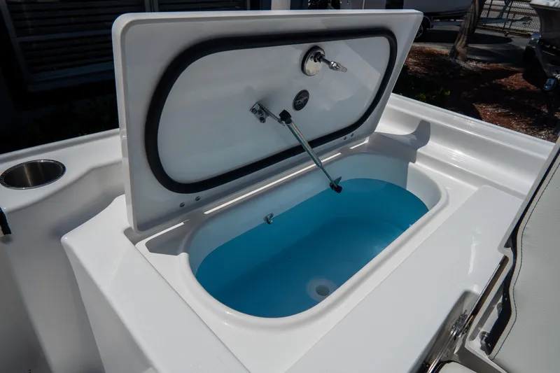 Slide: The Image of Open storage compartment on 2026 Tidewater 2410 Bay Max boat, featuring a blue interior. - 12