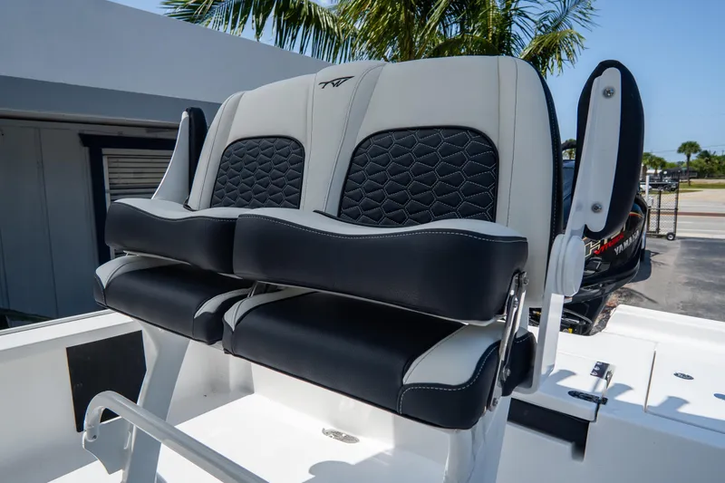 Slide: The Image of 2026 Tidewater 2410 Bay Max boat seats with black and white upholstery, palm tree background. - 17