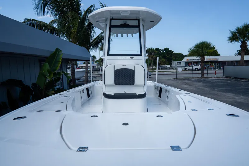 Slide: The Image of 2026 Tidewater 2410 Bay Max boat with center console, docked near palm trees. - 29