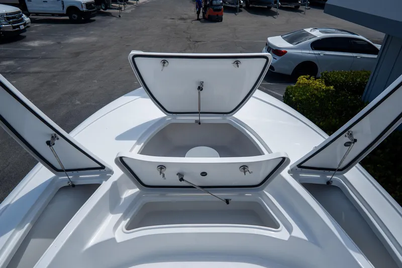 Slide: The Image of 2026 Tidewater 2410 Bay Max boat with open storage compartments on deck. - 31